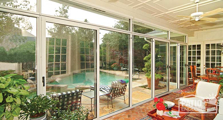 Three season room in white with transom enclosing an existing covered patio.