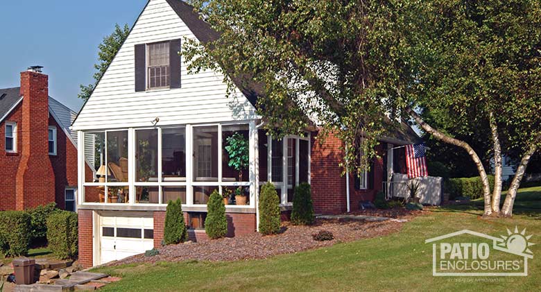 Three season room in white with glass knee wall enclosing an existing above-garage porch.