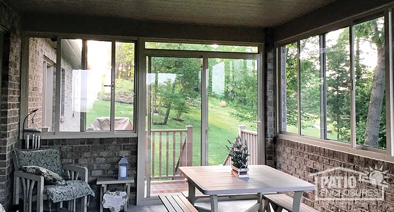 Elite three season room in sandstone enclosing an existing covered porch with brick knee wall.