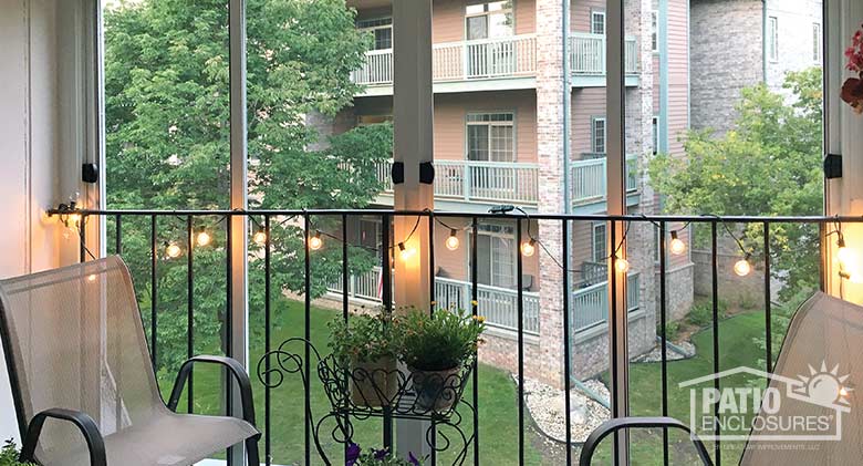 Screen room in white enclosing an existing upper level balcony.