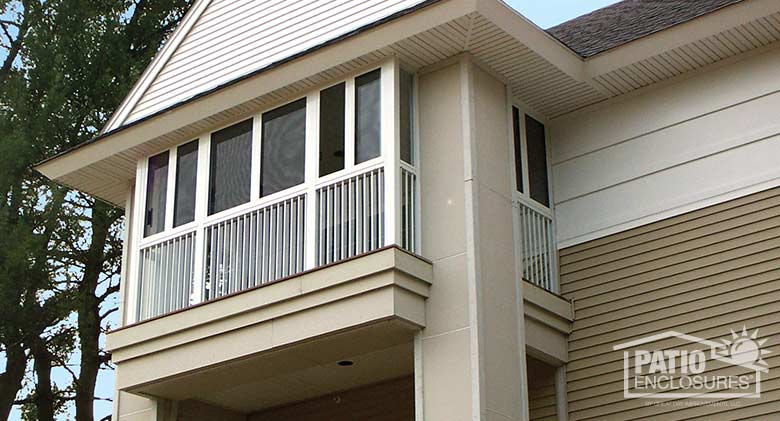 Screen room in white with picket railing system enclosing an existing upper level porch.