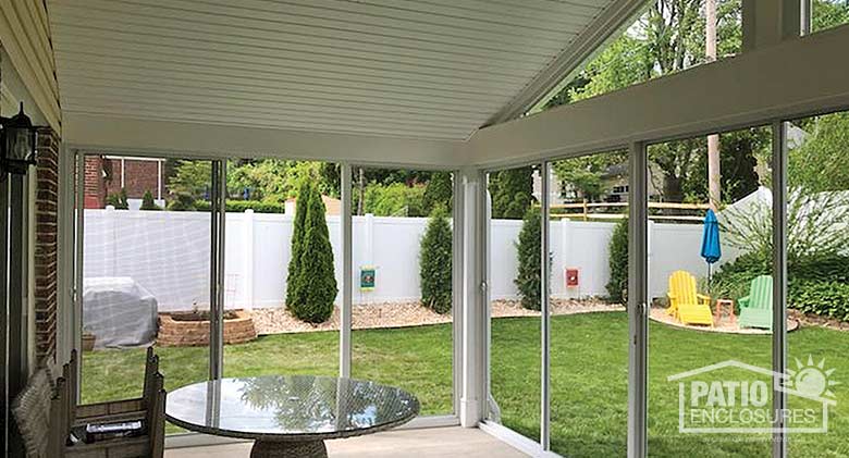 Interior view of screen room enclosing an existing covered patio with gable roof.