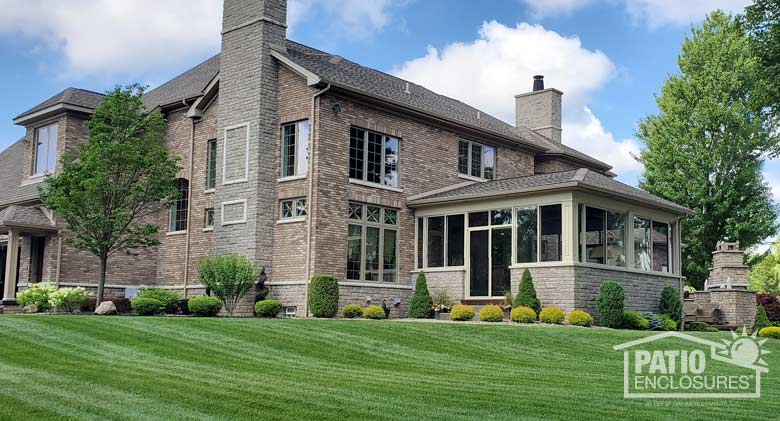 Elite three season room in sandstone enclosing an existing back covered porch.