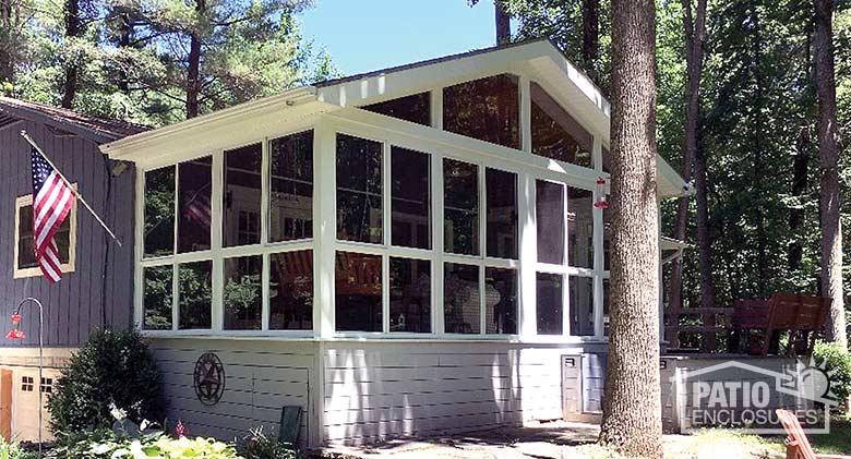 Three season room in white with glass knee wall enclosing an existing screen room.