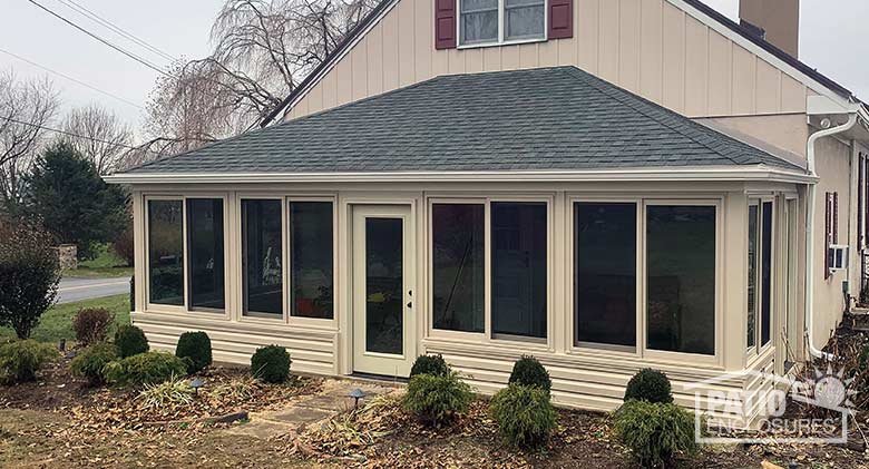 Four season room in sandstone with vinyl frame and solid knee wall enclosing an existing screen room.