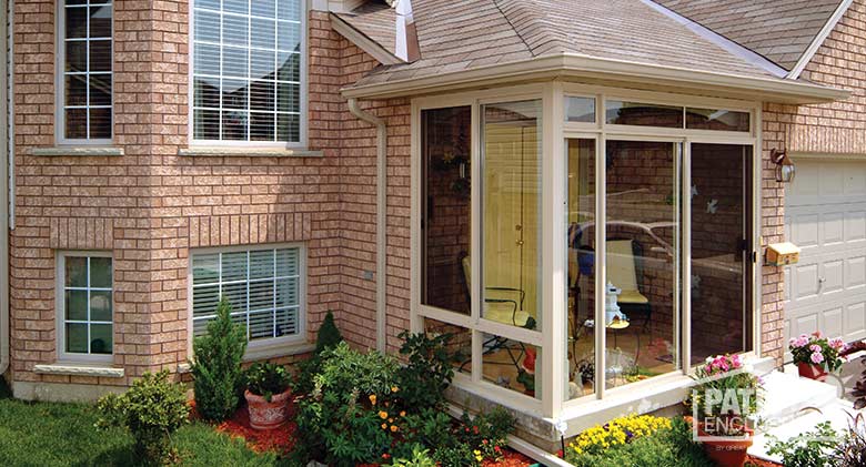 Three season room in sandstone with glass knee wall and transom enclosing an existing front porch.