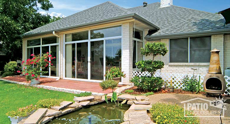 Three season room in white with insulated glass and transom enclosing an existing covered patio.