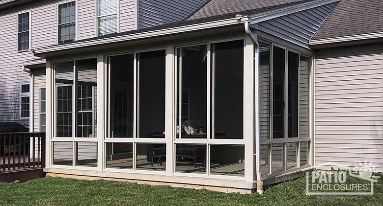 Three season room in sandstone with glass knee wall enclosing an existing screen room.