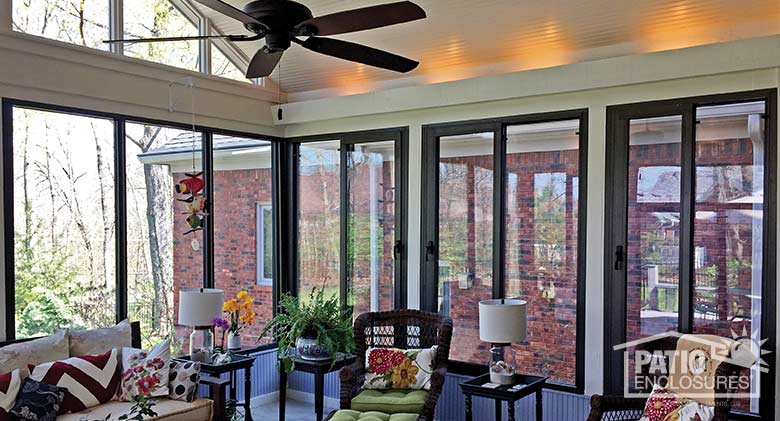 Bronze four season sunroom with aluminum frame enclosing existing covered porch.