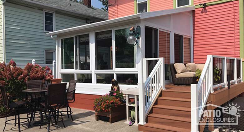 White four season sunroom with vinyl frame, glass knee walls and single-slope roof.
