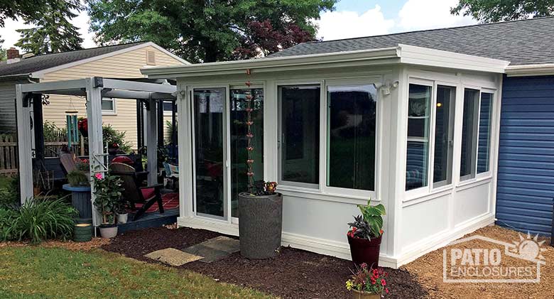 White four season room with vinyl frame, solid knee walls and single-sloped roof.