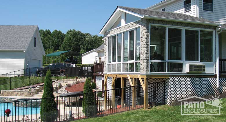 White four season sunroom with aluminum frame, glass knee walls, gable roof and stone fascia.