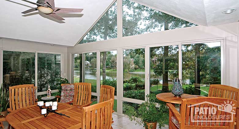 White four season sunroom with aluminum frame, glass knee walls and gable roof.