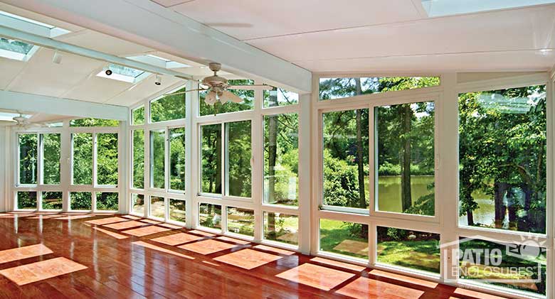 White four season room with vinyl frame, glass knee walls and glass roof panels.