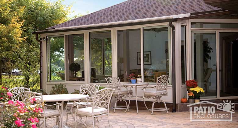 Sandstone four season room with solid knee wall and single-slope roof.