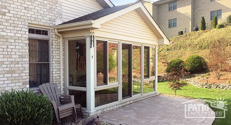 Sandstone four season sunroom with vinyl frame enclosing an existing covered patio.