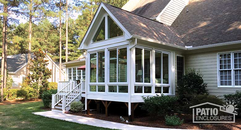 White four season sunroom with vinyl frame enclosing existing screen room.