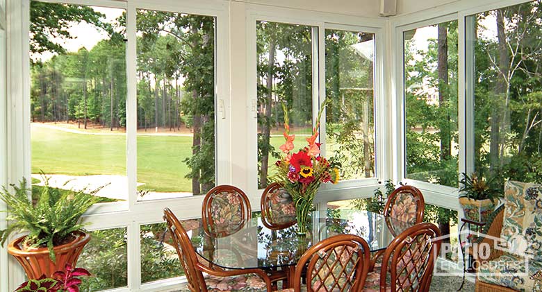 White four season sunroom with vinyl frame, glass knee walls and gable roof.