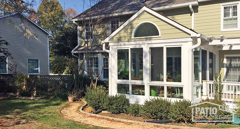 White four season room with vinyl frame and glass knee wall enclosing an existing screened porch.