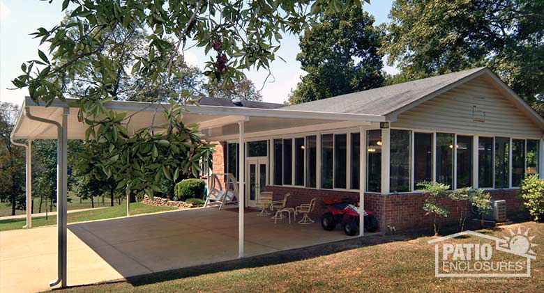 White patio cover provides protection for large gatherings and doubles as a car port.