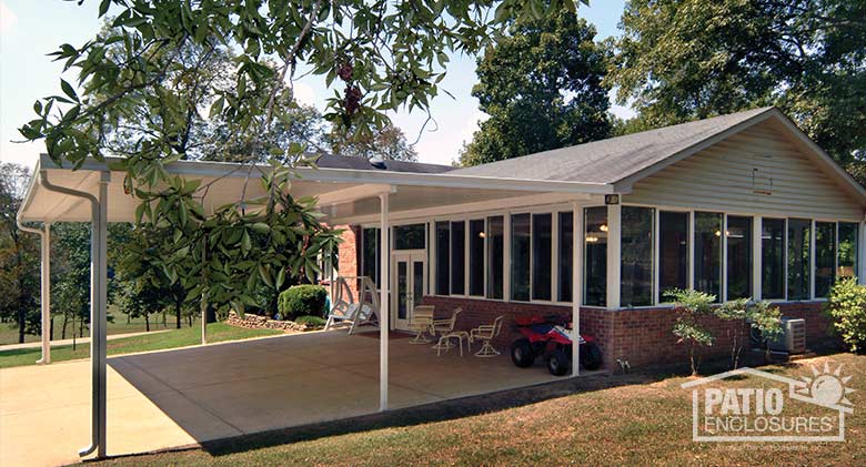 White patio cover provides protection for large gatherings and doubles as a car port.