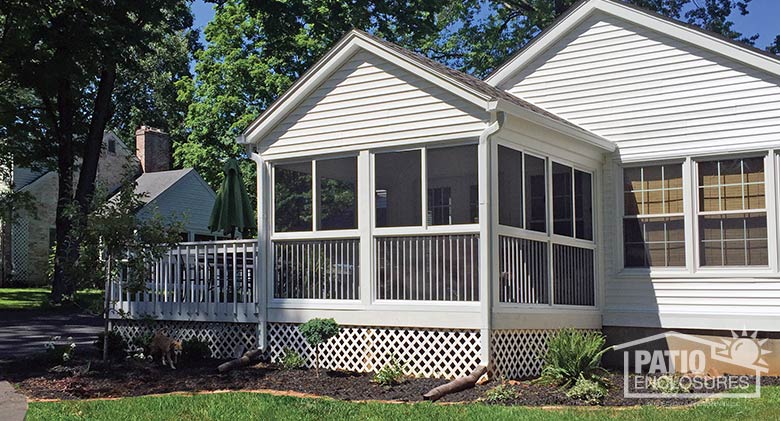 White screen room with custom, shingled, gable wood roof and picket railing system.