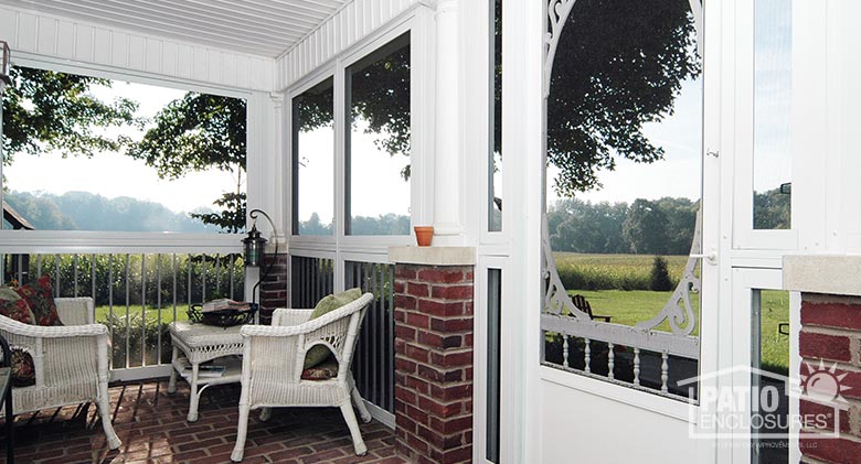 Interior view of a screen room with picket railing system enclosing a covered front porch.