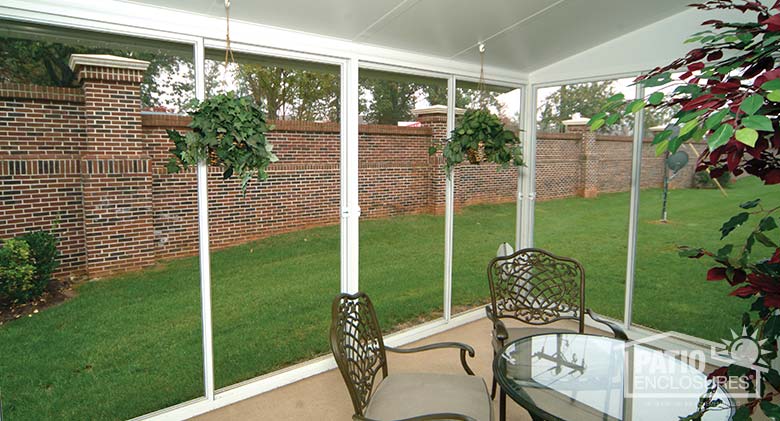 Interior view of screen room with white aluminum frame and single-slope roof.