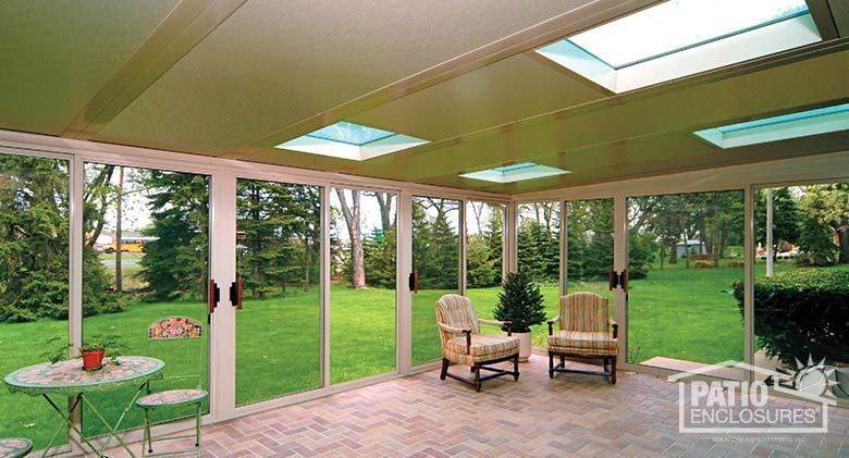 Sandstone screen room with glass roof panels and single-slope roof.