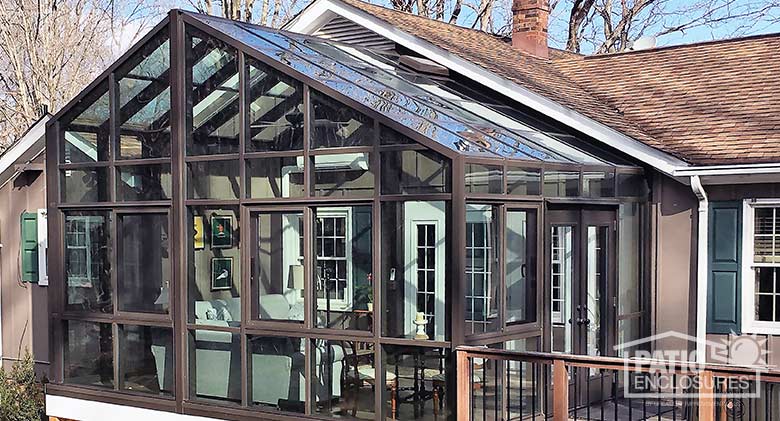 Bronze solarium with aluminum frame and gable roof.
