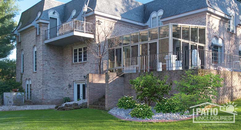 Sandstone solarium with aluminum frame and single-slope roof.