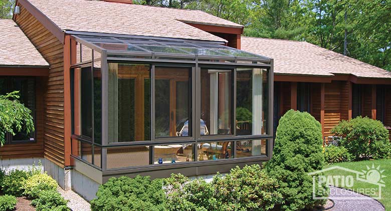 Bronze solarium with aluminum frame and single-slope roof.