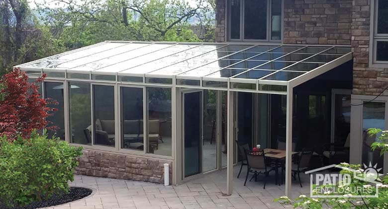 Sandstone solarium with aluminum frame and single-slope roof.