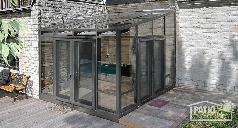 Bronze solarium with aluminum frame and single-slope roof.