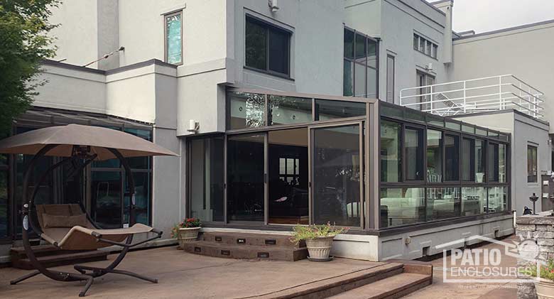 Bronze solarium with aluminum frame and single-slope roof.