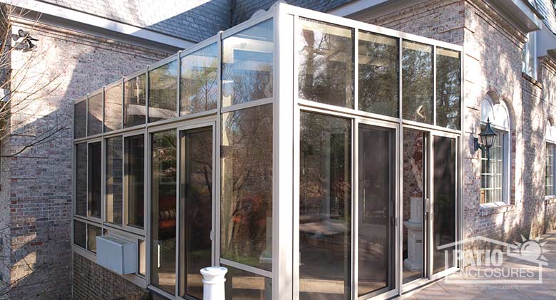 Sandstone solarium with aluminum frame and single-slope roof.