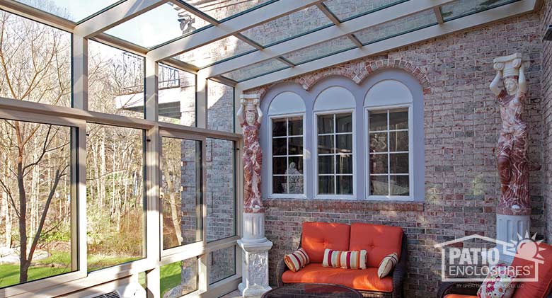 Sandstone solarium with aluminum frame and single-slope roof.