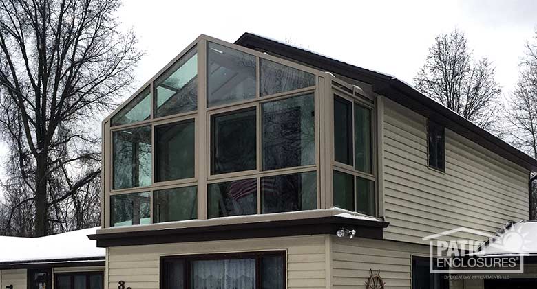 Sandstone solarium with aluminum frame and gable roof.