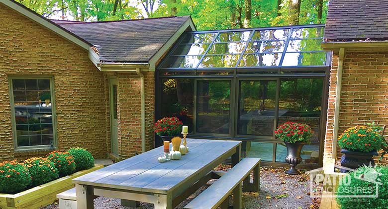 Bronze solarium with aluminum frame and gable roof.