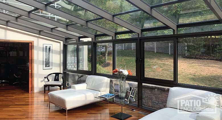 Bronze solarium with aluminum frame and single-slope roof.