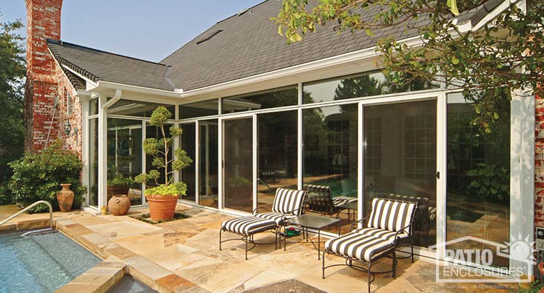 White three season sunroom with transoms enclosing an existing covered patio.