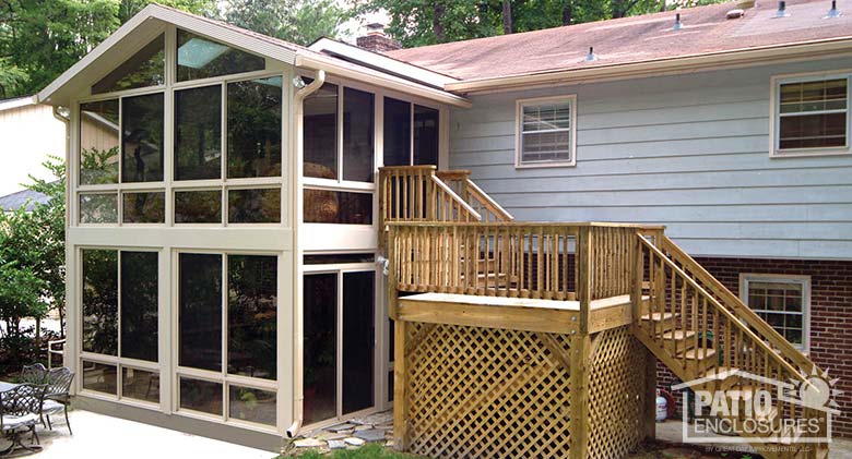 Double-decker sandstone three season sunroom with insulated glass and gable roof.