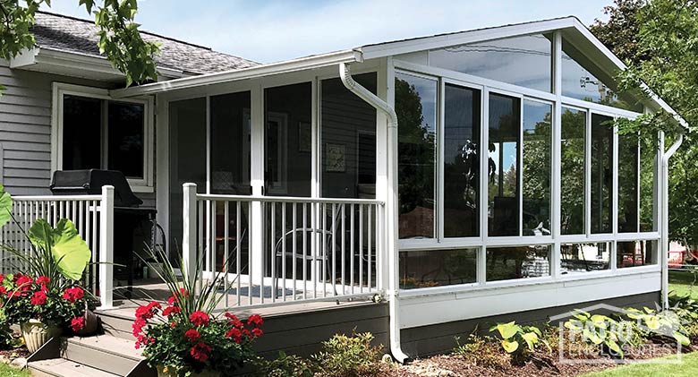 Three season sunroom with glass knee wall, gable roof and attached deck.