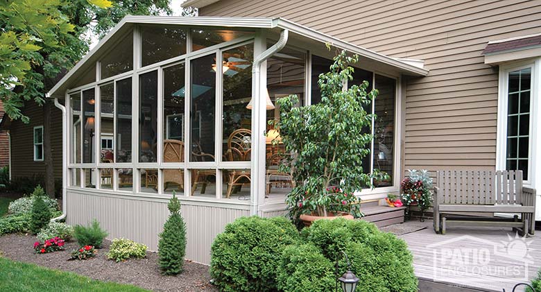 Three season sunroom with sandstone aluminum frame and gable roof.