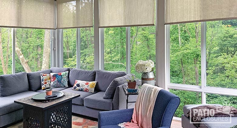 Elite three season sunroom with glass knee wall and roller shades.