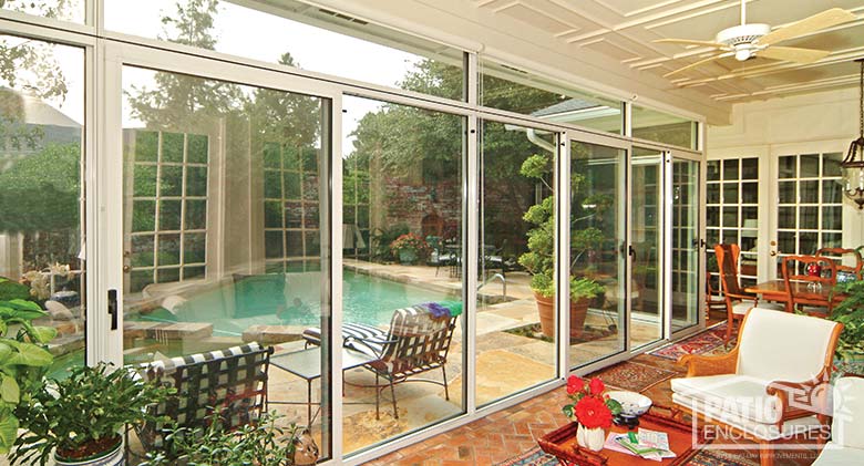 White three season sunroom with transoms enclosing an existing covered patio.