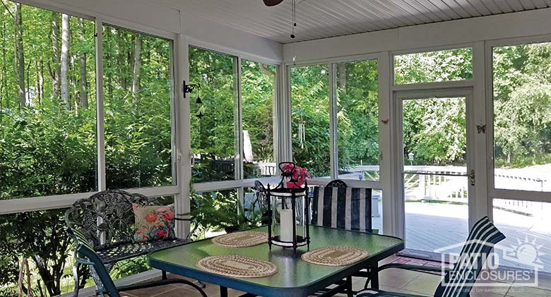 Three season sunroom with glass knee walls enclosing an existing covered porch.