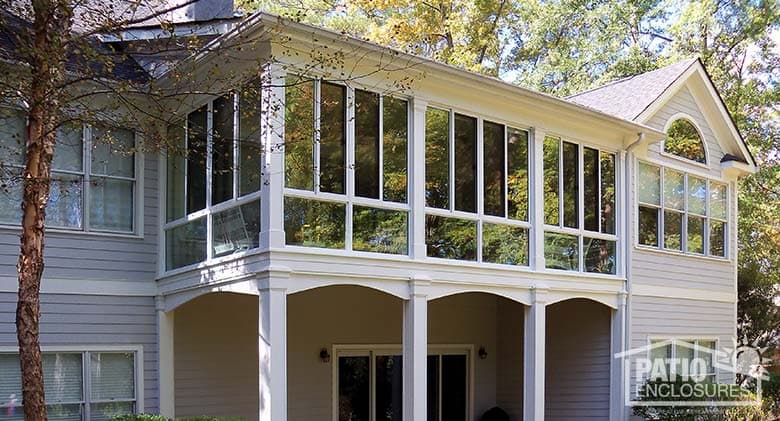 Three season sunroom with glass knee walls enclosing a second-story covered porch.
