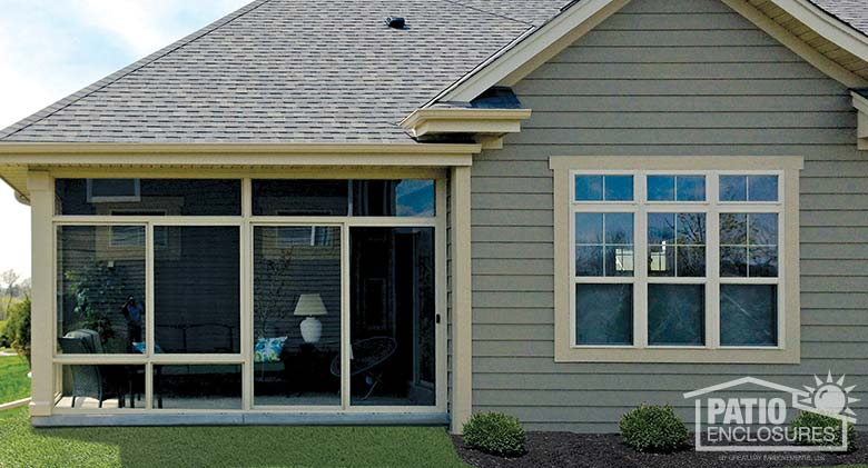 Sandstone three season room enclosing a covered patio.