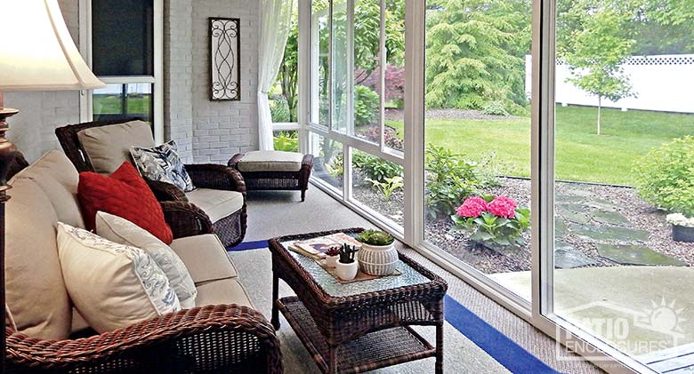 Elite three season sunroom with white aluminum frame, gable roof and custom wood ceiling.